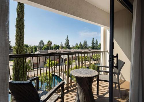 a balcony with two chairs and a table with a view at Hilton Stockton in Stockton