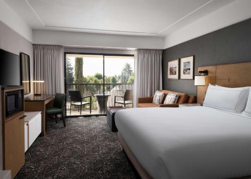 ein Hotelzimmer mit einem Bett und einem Wohnzimmer in der Unterkunft Hilton Stockton in Stockton
