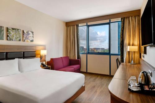セビリアにあるヒルトン ガーデン イン セビリアのベッドと大きな窓が備わるホテルルームです。