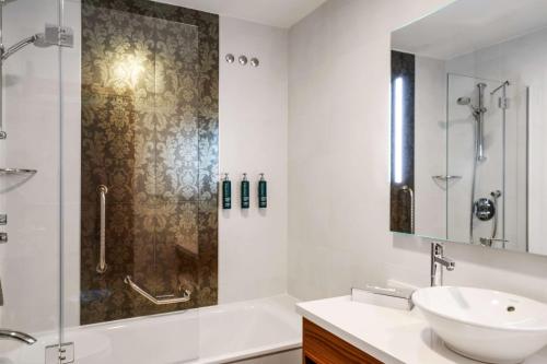 a bathroom with a tub and a sink and a shower at Hilton Garden Inn Sevilla in Seville