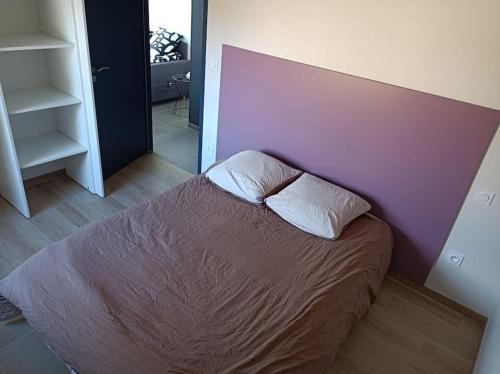 un lit avec deux oreillers dessus dans une chambre dans l'établissement GITE LA POISSONNIERE, à Sevremont