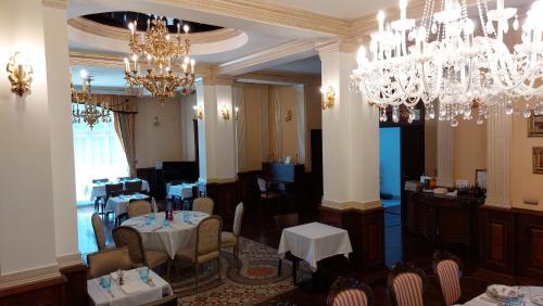 a dining room with chandeliers and tables and chairs at Castle Garden *** in Szombathely