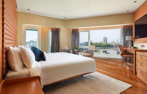 ロンドンにあるパーク プラザ ロンドン リバーバンクのベッド、デスク、キッチンが備わるホテルルームです。