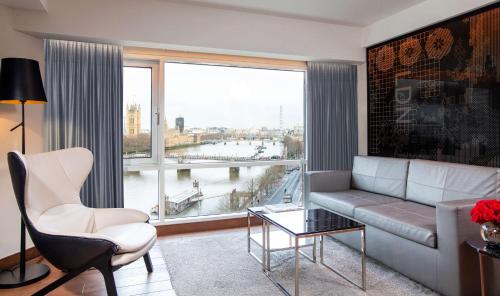 a living room with a couch and a large window at Park Plaza London Riverbank in London