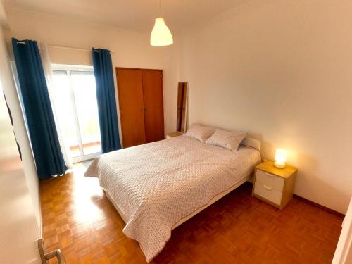 een slaapkamer met een bed en een lamp op een tafel bij Sintra T2 Rinchoa in Sintra
