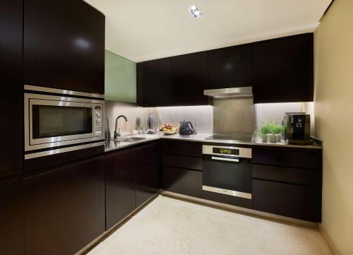 a kitchen with black cabinets and a microwave at Park Plaza London Riverbank in London