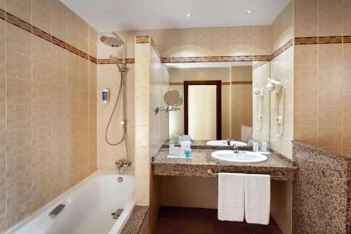W łazience znajduje się wanna, umywalka i prysznic. w obiekcie Occidental Jandía Mar w mieście Morro del Jable