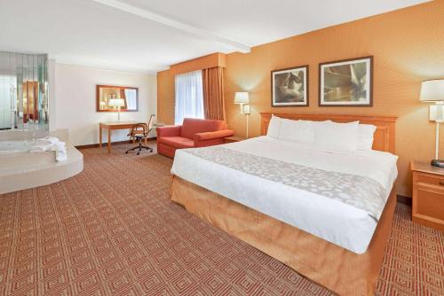 a hotel room with a large bed and a bathroom at La Quinta by Wyndham Salt Lake City - Layton in Layton