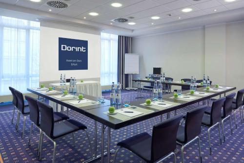 ein großer Konferenzraum mit einem langen Tisch und Stühlen in der Unterkunft Dorint Hotel am Dom Erfurt in Erfurt