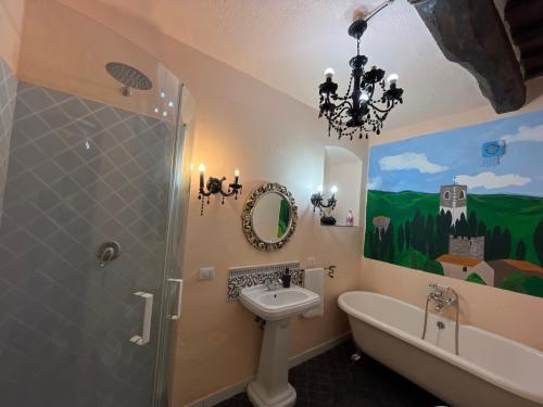 a bathroom with a sink and a bath tub and a chandelier at Il Fiorino di Badia in Badia A Passignano