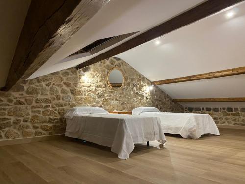 a room with two beds and a stone wall at CASA do CAMPO in Lestrove