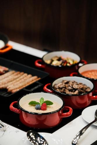 a table topped with bowls of food and desserts at Palatinus Boutique Hotel in Pécs