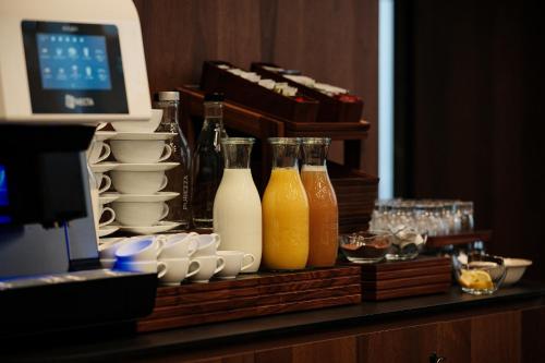 a counter with bottles of milk and plates and a computer at Palatinus Boutique Hotel in Pécs