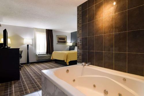 a hotel room with a tub and a bed at Quality Inn Aurora - Naperville Area in Aurora