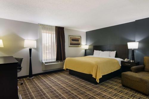 a hotel room with a bed and a chair at Quality Inn Aurora - Naperville Area in Aurora