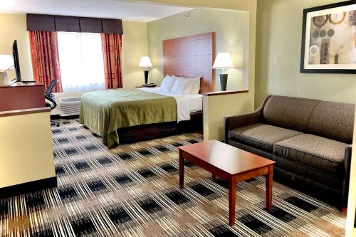 a hotel room with a bed and a couch at Quality Inn & Suites Wisconsin Dells Downtown - Waterparks Area in Wisconsin Dells