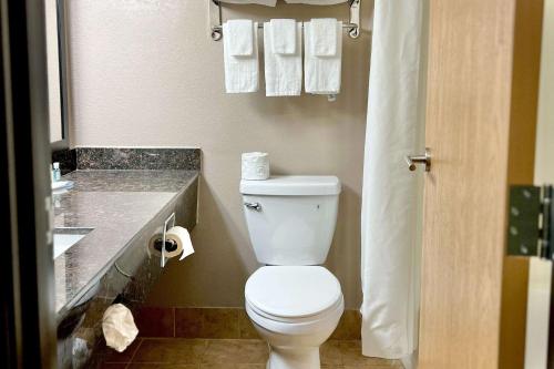 a bathroom with a toilet and a sink with towels at Quality Inn & Suites Wisconsin Dells Downtown - Waterparks Area in Wisconsin Dells