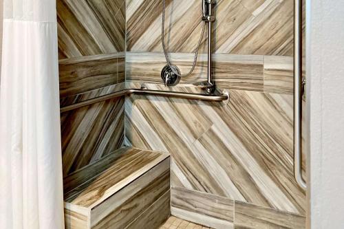 y baño con ducha con paneles de madera. en Quality Inn & Suites Wisconsin Dells Downtown - Waterparks Area en Wisconsin Dells
