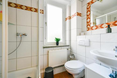 a bathroom with a toilet and a sink at Fürst-Pückler-Apartment_bis 6 Personen_Waschmaschine_Küche_2x Parkplätze_Terrasse_Netflix in Cottbus