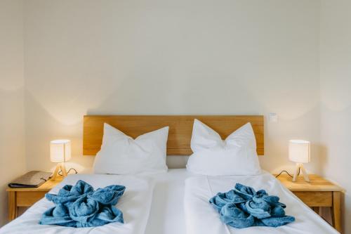 a white bed with blue flowers on it at Käferberghof 