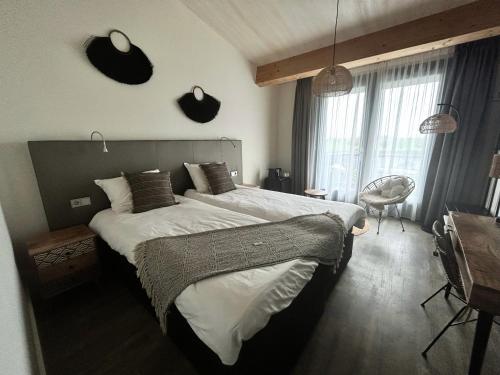 a bedroom with a large bed and a desk at Fruitpark Hotel & Spa in Ochten