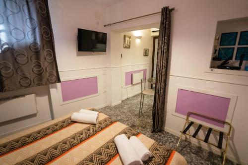 a room with a bed and a tv on a wall at San Polo Studio in Venice
