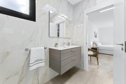 a white bathroom with a sink and a mirror at Casahost Fontaine Bleue Villa in Tías