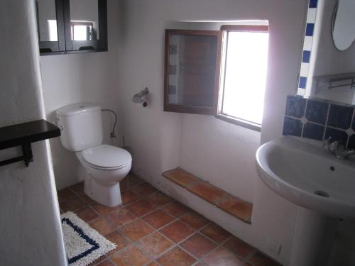 ein Bad mit einem WC, einem Waschbecken und einem Fenster in der Unterkunft Beautifully renovated village house with spectacular views in Canillas de Albaida