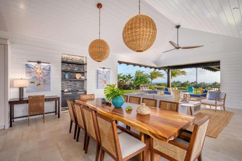 a dining room and living room with a table and chairs at Kauai Luxury Vacation Villas in Koloa