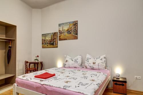 a bedroom with a bed with pink and white sheets at City and Calmness in Budapest