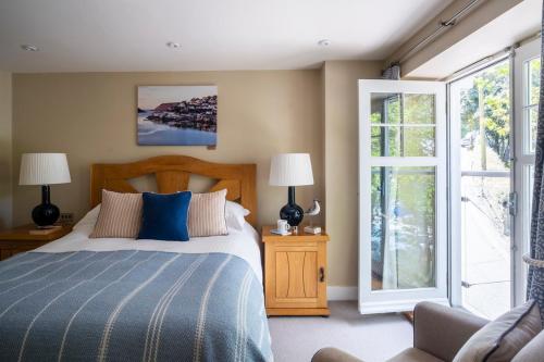 a bedroom with a bed with a blue comforter at South Sands Hotel in Salcombe