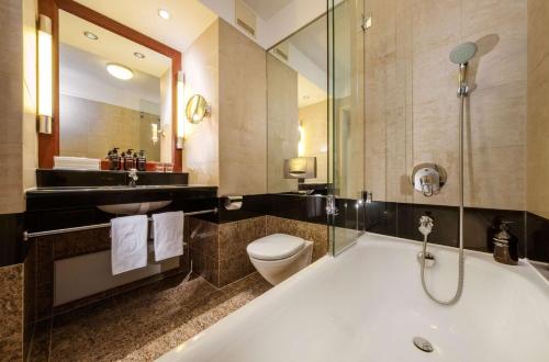 a bathroom with a tub and a toilet and a sink at Hotel Nassauer Hof in Wiesbaden