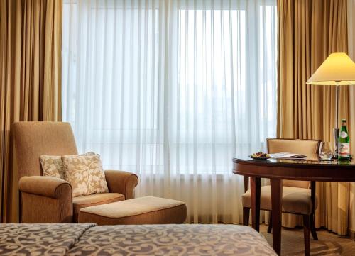 ヴィースバーデンにあるホテル ナッサウアー ホフのデスク、椅子、ベッドが備わる客室です。