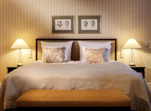 a bedroom with a large bed with two lamps at Hotel Nassauer Hof in Wiesbaden