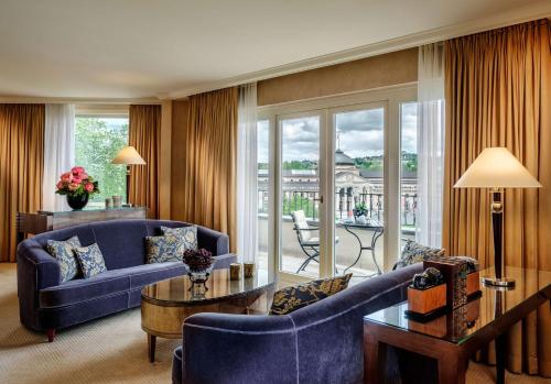 a living room with blue furniture and a large window at Hotel Nassauer Hof in Wiesbaden