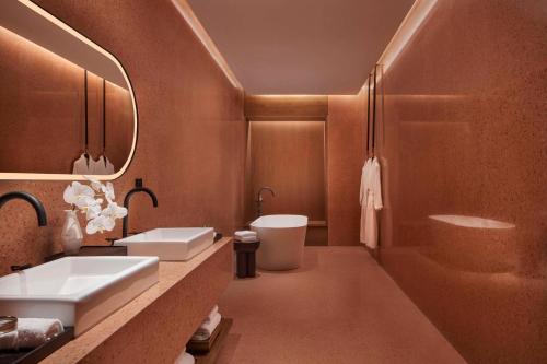 a bathroom with two sinks and a tub and a toilet at TAOXICHUAN Hotel in Jingdezhen