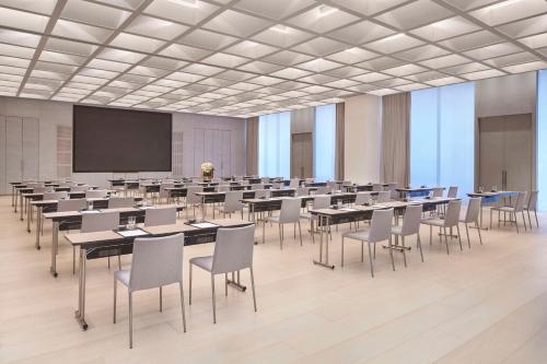 a large room with tables and chairs and a projection screen at TAOXICHUAN Hotel in Jingdezhen