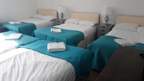 een kamer met vier bedden en handdoeken erop bij King garden hotel in Londen