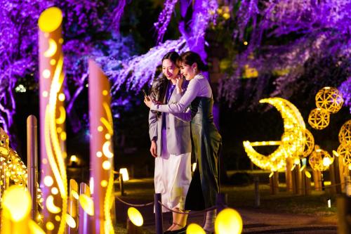 a man and woman standing in front of a display of lights at Grand Prince Hotel Shin Takanawa in Tokyo