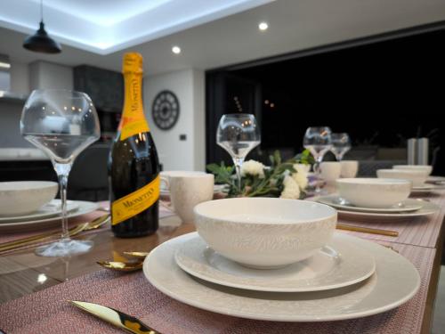 a table with a bottle of wine and a bowl on it at Homely 5 bed Cottage 30 mins to Heathrow, London, Legoland, Windsor Castle in Little Missenden