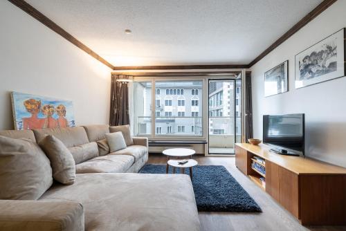 uma sala de estar com um sofá e uma televisão em Au Reduit em St. Moritz
