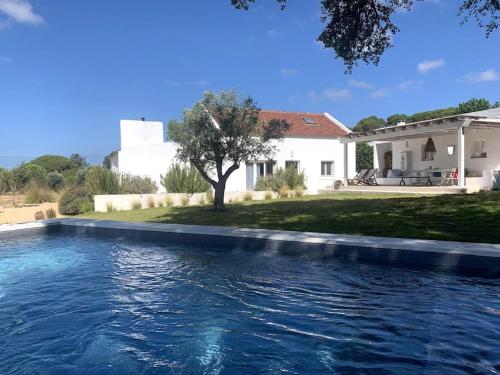 a swimming pool in front of a house at Property between Melides and Aberta Nova beach in Melides
