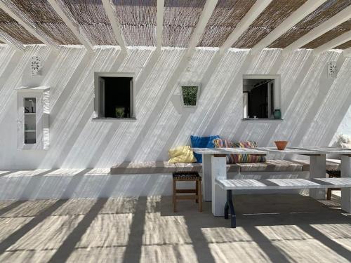 a white building with tables and benches in it at Property between Melides and Aberta Nova beach in Melides