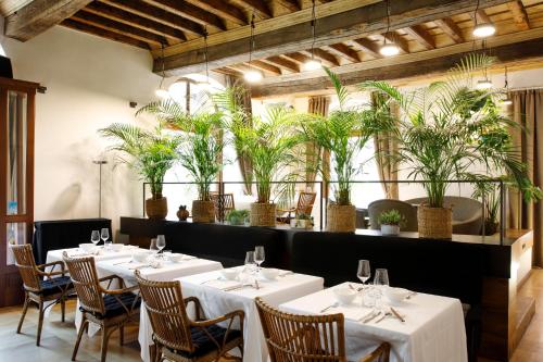 ein Restaurant mit weißen Tischen, Stühlen und Topfpflanzen in der Unterkunft Casa del Pingone in Turin