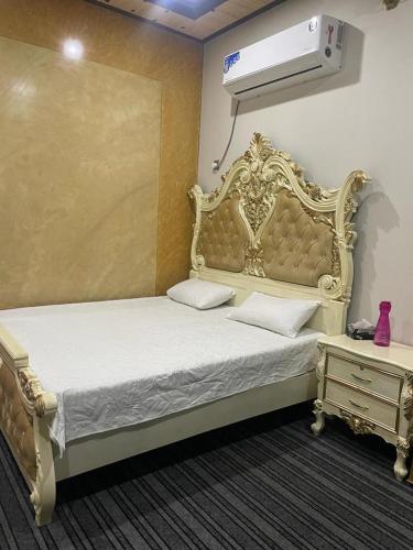 ein Schlafzimmer mit einem Bett mit einem weißen Bettrahmen in der Unterkunft Warraich villa gt raod gujrat entire in Gujrāt