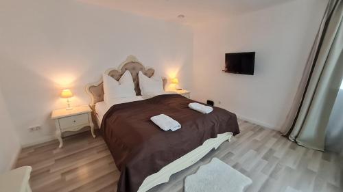 a bedroom with a large bed with two lamps and a tv at Villa unter dem Schloss in Cleebronn