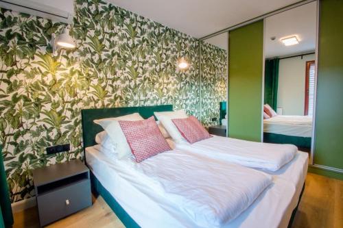 a bedroom with a bed with white sheets and pink pillows at SPA Waterlane Island Deluxe 2 by Grand Apartments in Gdańsk