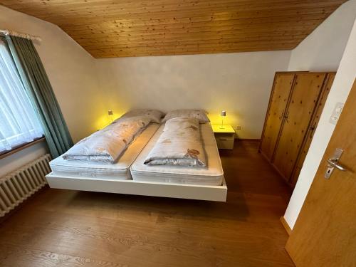 a large bed in a room with a wooden ceiling at Chesa Talvo, Samedan in Samedan