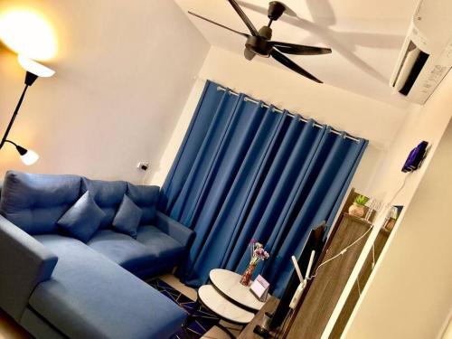 ein blaues Sofa im Wohnzimmer mit Deckenventilator in der Unterkunft Dilla Homestay At Bangi UKM Kajang in Kajang