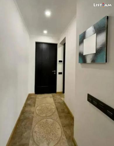 a hallway with a black door and a rug at APARTMENT in Yerevan,Komitas Avenue in Yerevan